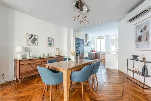 une salle à manger avec une table en bois et des chaises bleues dans l'établissement Appartement Mercier - Welkeys, à Lyon