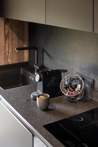 a kitchen counter with a toaster and a bowl of food at Stay COOPER I DIAMANTIDI Lodge - Modern Mountain Chalet in the Dolomites in Obereggen