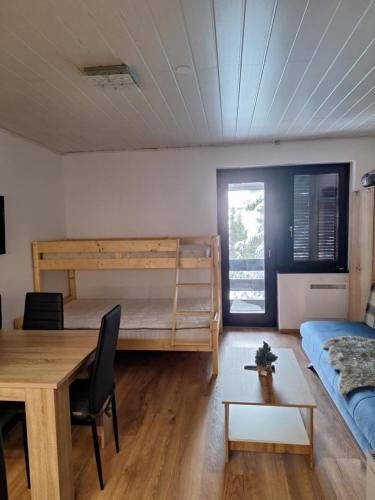 a bedroom with a bunk bed and a table and a desk at Apartma Rogla Gaber 63 in Zreče
