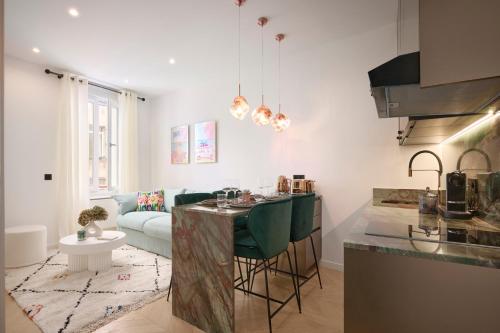 a kitchen and living room with a table and a couch at Le XV Cannes in Cannes