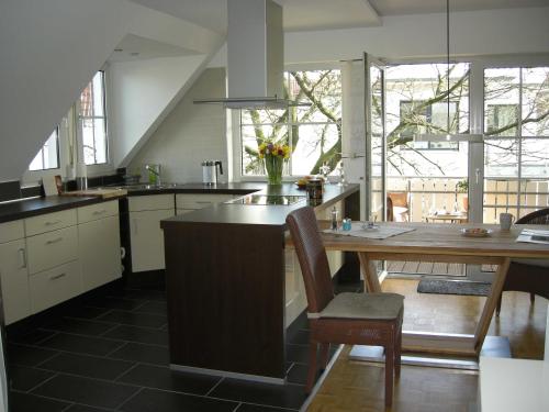 a kitchen with a table with a vase of flowers on it at Hideaway - Ibbenbüren in Ibbenbüren