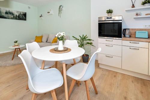 a kitchen and living room with a white table and chairs at Ferienwohnung Familie Busam in Oberkirch