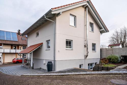 a white house with a gambrel roof at Ferienwohnung Familie Busam in Oberkirch