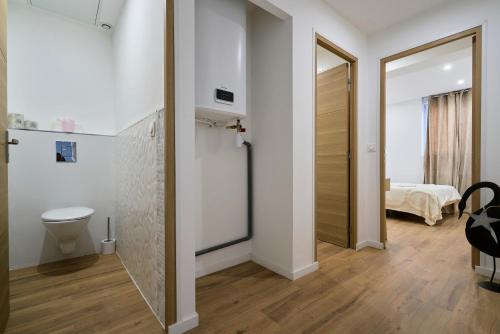 La salle de bains est pourvue de toilettes et d'une porte menant à une chambre. dans l'établissement T2 chic et contemporain au RDC - proche de Lille, à Mons-en-Baroeul