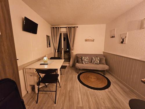 a small living room with a couch and a table at Studio Princesse Galitzine in Cauterets