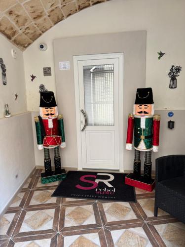 two nutcrackers in a living room with a door at Rebel suite family in Gravina in Puglia