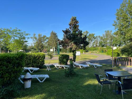 a group of tables and chairs in the grass at Mobile home in Vogelgrun