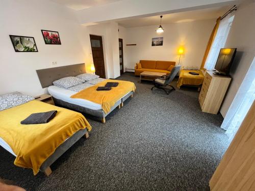 pokój hotelowy z dwoma łóżkami i kanapą w obiekcie Centrum Noclegi w mieście Krynica Zdrój