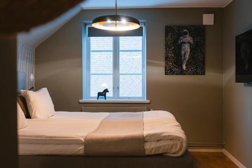 a bedroom with a bed and a window at Köpmans Boutique Hotel & Bistro in Höganäs