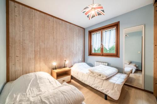 une chambre avec deux lits et un miroir dans l'établissement Fleur de sel - Agréable 2 chambres avec terrasse, à Morzine