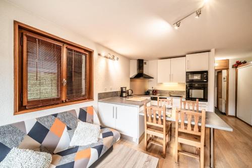un salon avec un canapé et une cuisine dans l'établissement Fleur de sel - Agréable 2 chambres avec terrasse, à Morzine