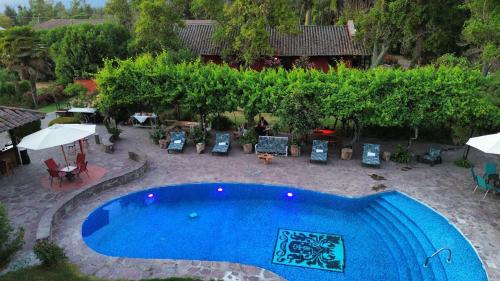 an overhead view of a swimming pool with chairs and umbrellas at Casona Lo Aguirre , Hospedaje de Temporada Cálidas in Talagante