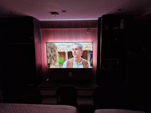 a television with a man on it in a room at Flat Cabo Branco - NOVO! in João Pessoa