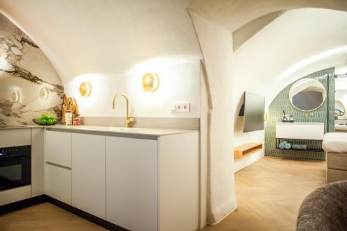 a kitchen with a sink and a living room at The Stork - In luxe logeren aan de Oudegracht, Centrum Utrecht in Utrecht