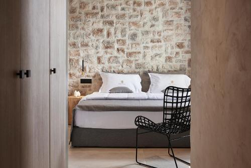 a bedroom with a bed and a black chair at The Sand Villa in Agios Nikolaos