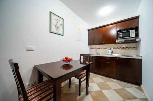a small kitchen with a table and a microwave at SUNce Palace Apartments with free offsite parking in Dubrovnik