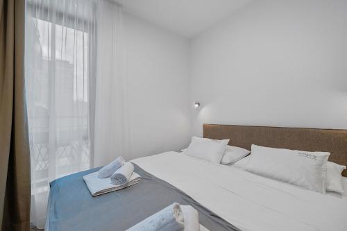 a bedroom with a large white bed with a window at Enjoy Apartments and Suites in Zagreb