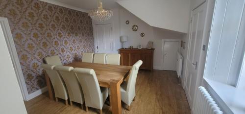 a dining room with a wooden table and chairs at 4 Private bedroom house with 3 parking spaces free in Perth