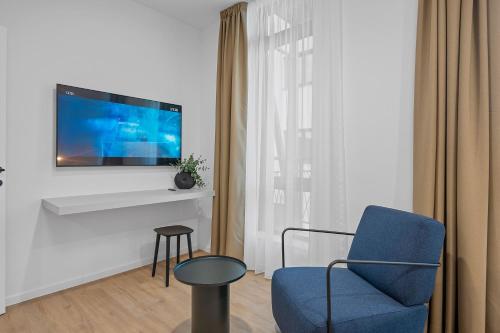 a living room with a blue chair and a tv at Enjoy Apartments and Suites in Zagreb