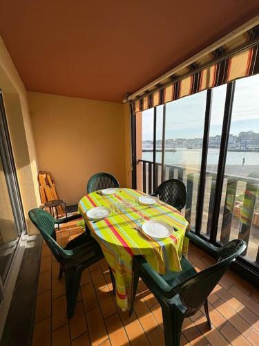 une table et des chaises dans une pièce avec vue sur l'océan dans l'établissement Le Marin, à Hossegor
