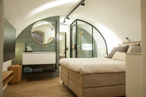 a bedroom with a bed with a mirror and a sink at The Stork - In luxe logeren aan de Oudegracht, Centrum Utrecht in Utrecht