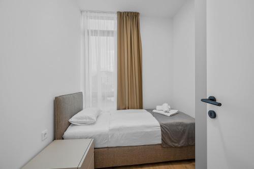 a small bedroom with a bed and a window at Enjoy Apartments and Suites in Zagreb
