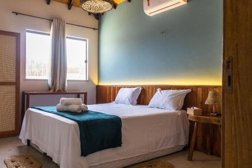 a bedroom with a bed with a towel on it at Vila Insular - Beira-mar - 3 casas p/ até 36 in Cajueiro