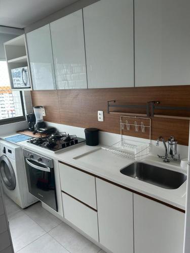 a kitchen with a sink and a washing machine at Flat Boa Viagem -500 m praia - Golden Style in Recife