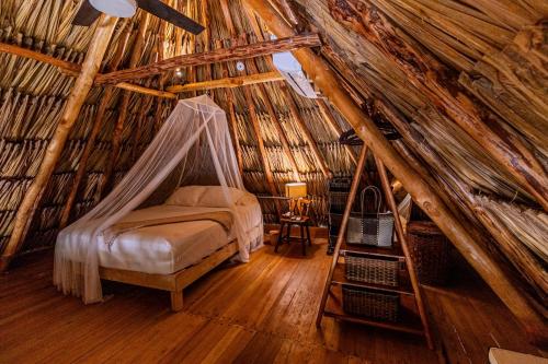 a bedroom with a bed in a thatched room at Casa Laila Cozy House in Bacalar Center in Bacalar