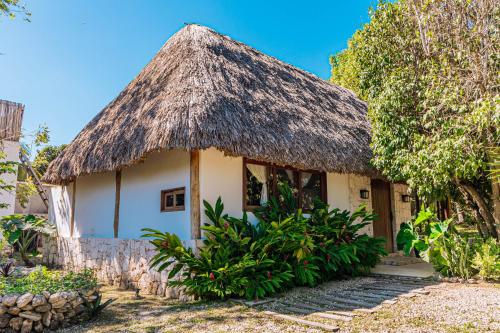 a small house with a thatched roof at Casa Laila Cozy House in Bacalar Center in Bacalar