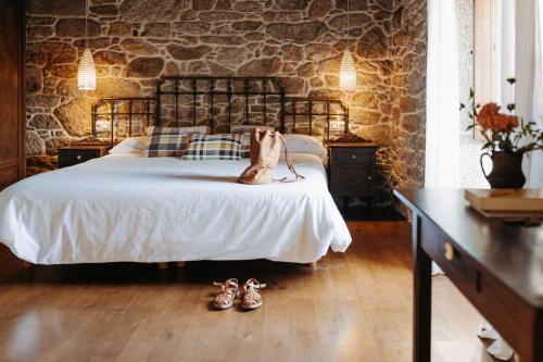 a dog sitting on a bed in a bedroom at Arrueiro in Laxe