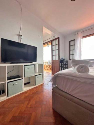 a bedroom with a large television and a bed at Casa Valhalla in Funchal