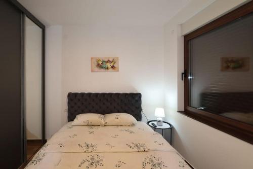 a bedroom with a bed with two pillows on it at Lux Apartment Rose Avenue in Kragujevac