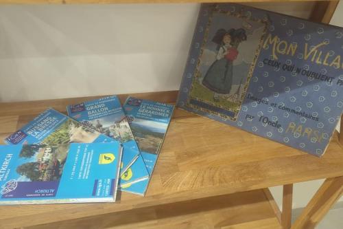 four books sitting on a wooden table at Villa vue panoramique Vosges in Altkirch
