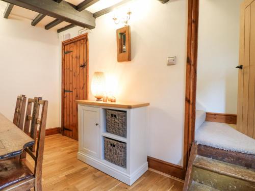 a living room with a table and a bed at Cherry Tree Cottage in Nottingham