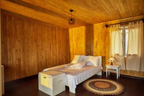 a bedroom with a bed in a wooden room at Sunset Madiorano in Tuléar