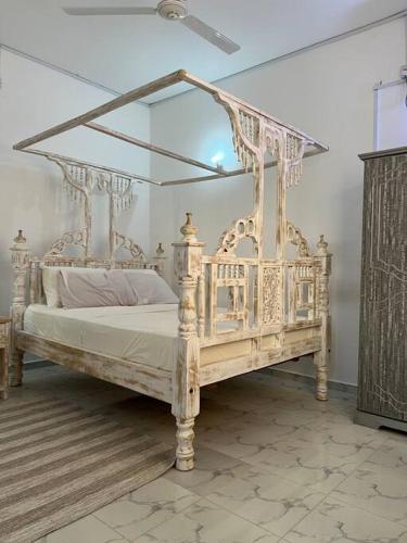 a white bed with a canopy in a room at Nani Coastal Retreat Modern Bungalow with Terrace in Kilifi