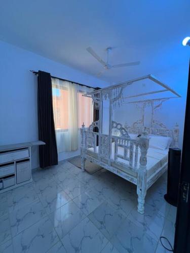 a bedroom with a white bed with a canopy at Nani Coastal Retreat Modern Bungalow with Terrace in Kilifi