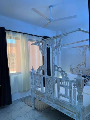 a white bed in a room with a blue ceiling at Nani Coastal Retreat Modern Bungalow with Terrace in Kilifi