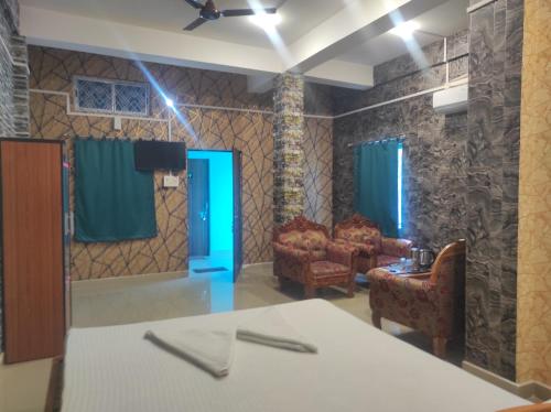 a living room with a table and chairs and a blue door at Rani Guest House in Gauhāti