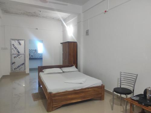 a bedroom with a bed and a table and a chair at Rani Guest House in Gauhāti