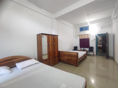 a hotel room with two beds and a mirror at Rani Guest House in Gauhāti