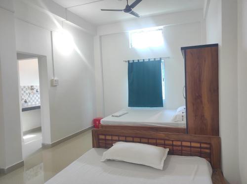 a bedroom with a bed with a mirror and a window at Rani Guest House in Gauhāti