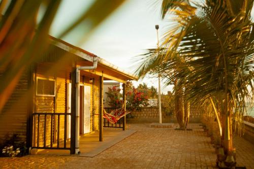 a house with a palm tree in front of it at Sunset Madiorano in Tuléar