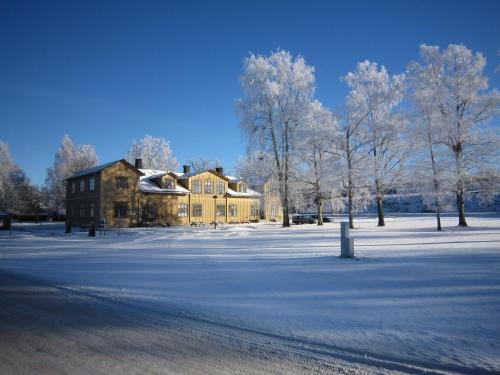 a house in a field with snow on the ground at Ediths Pensionat in Karlsborg