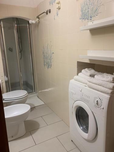 a bathroom with a washing machine and a toilet at CASABARBARA lerici in Lerici