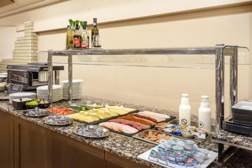a buffet line with many different types of food at Aranyhomok Business-City-Wellness Hotel in Kecskemét