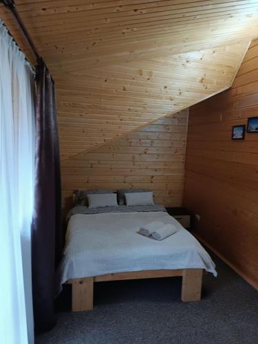 a bedroom with a bed in a wooden cabin at Чан-садиба Гуцульська пісня in Mykulychyn