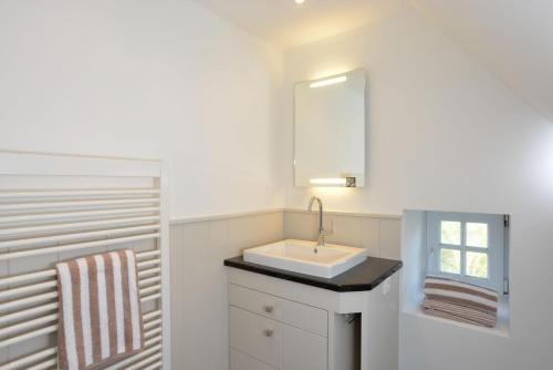 een badkamer met een wastafel en een spiegel bij Witthüs 15 in Wenningstedt