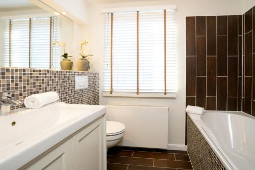 a bathroom with a sink and a toilet and a tub at Ferienhaus Frieda Sylt in Tinnum